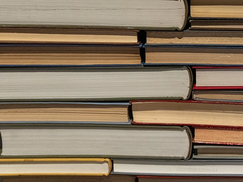 Stacked hardback books viewed side-on.