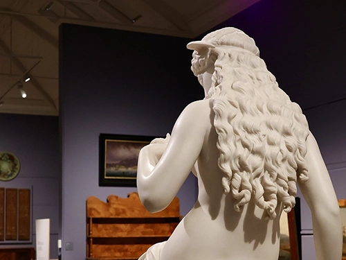 White marble statue displayed in a museum gallery.